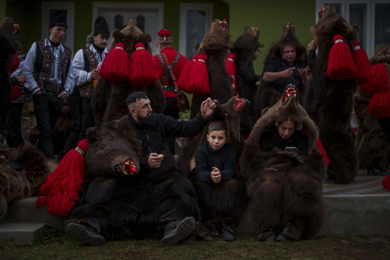 Les membres de la meute d'ours Sipoteni se détendent après leur représentation à Preluci, dans le nord de la Roumanie, le mardi 26 décembre 2023.