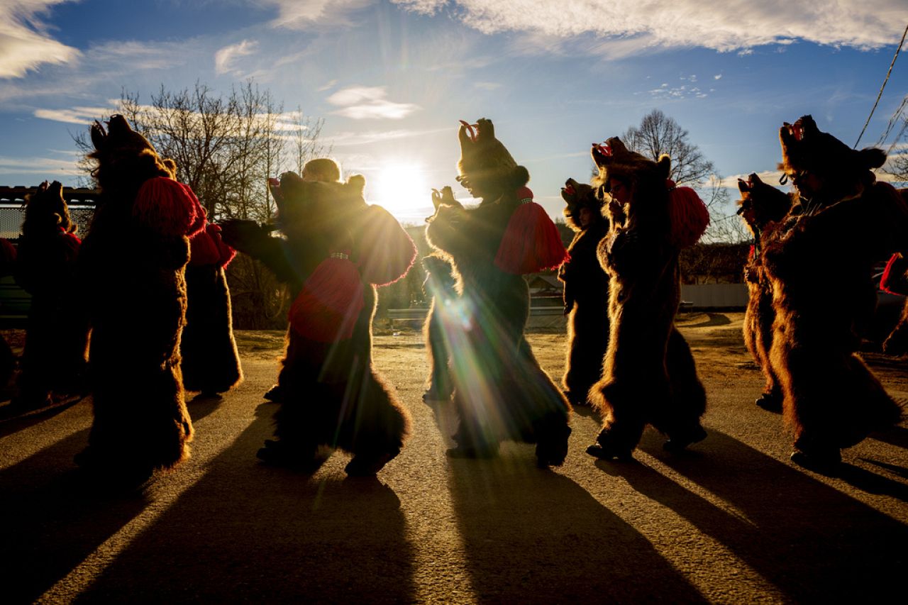 Des membres de la meute d'ours Sipoteni marchent à Vasieni, dans le nord de la Roumanie, le mardi 26 décembre 2023, tout en visitant les maisons du village pour exécuter la danse rituelle de l'ours.