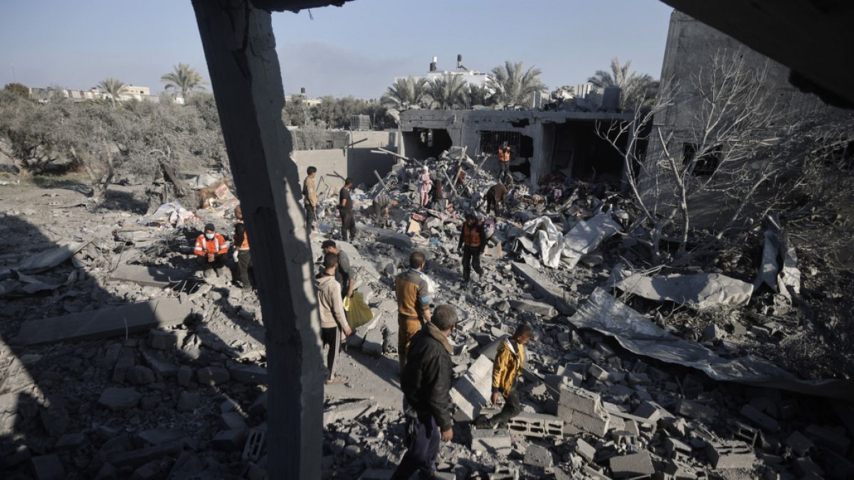 Palestinians inspect the damage to a destroyed house after Israeli air strikes on Khan Younis in the southern Gaza Strip, Sunday, December 31, 2023.