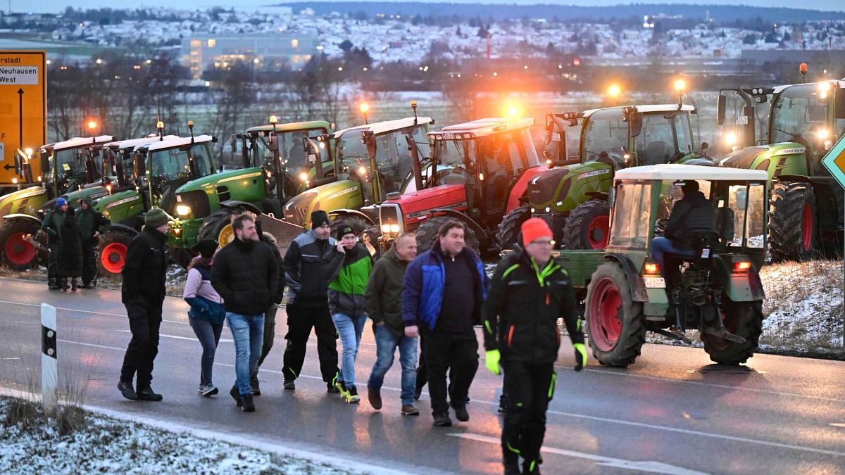 Farmers block the access road to the A8 highway with tractors in Neuhausen, Monday, Jan. 8, 2024.