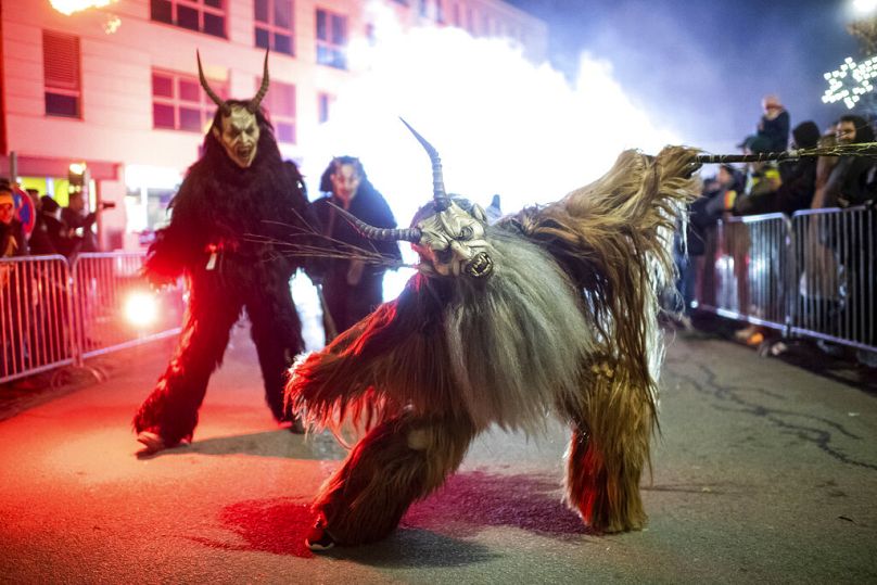 Un participant portant un costume traditionnel de Krampus et un masque se produit lors d'une course de Krampus à Hollabrunn, novembre 2022
