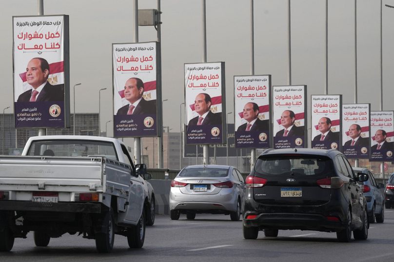 Des véhicules passent près de banderoles soutenant le président égyptien Abdel Fattah el-Sissi pour les élections présidentielles, au Caire, décembre 2023.