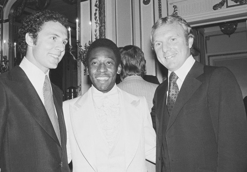 Le capitaine de l'équipe de la Coupe du monde 1974 d'Allemagne de l'Ouest, Franz Beckenbauer, à gauche, la star du football Pelé, au centre, et Bobby Moore, capitaine de l'équipe anglaise de football de la Coupe du monde 1966 posent.