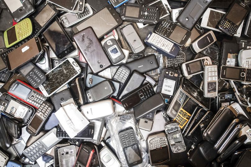 Les téléphones portables mis au rebut remplissent une poubelle dans l'entrepôt de l'entreprise Out Of Use à Beringen, en Belgique.
