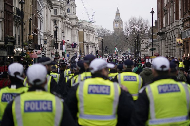La police suit la marche tandis que les manifestants brandissent des banderoles, des drapeaux et des pancartes lors d'une manifestation en soutien au peuple palestinien à Gaza, à Londres, le samedi 13 janvier 2024.