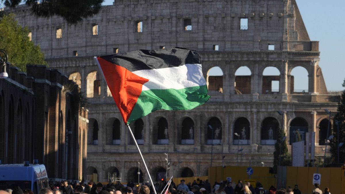 A Palestinian flag is waved in front of the Colosseum, during a rally in support of the Palestinians in Rome, Saturday, Jan. 13, 2024. (AP Photo/Gregorio Borgia)