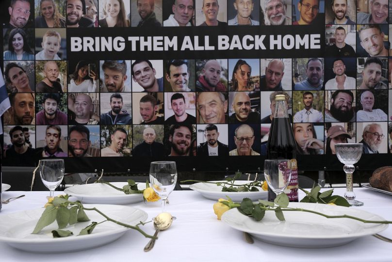 Des photos d'otages kidnappés par le Hamas sont placées près d'une table dressée vendredi lors d'une manifestation devant la Cour internationale de Justice à La Haye, aux Pays-Bas.