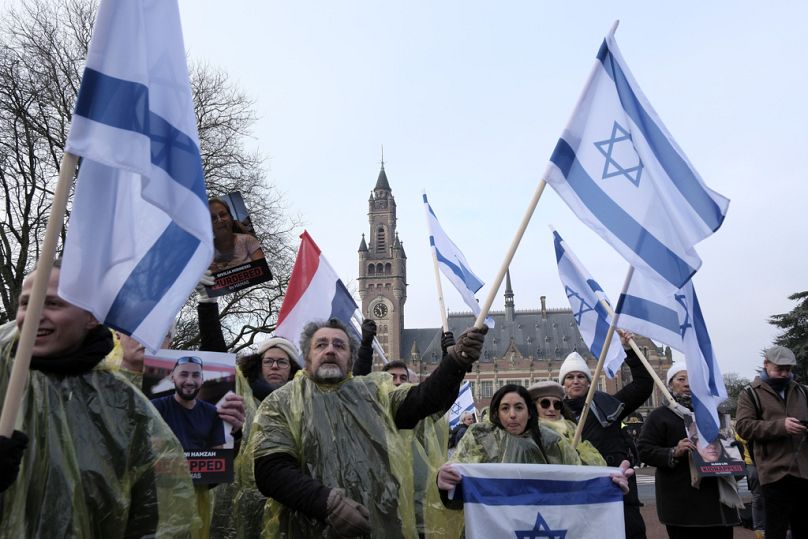 Des manifestants brandissent des drapeaux israéliens et brandissent des photos des otages kidnappés par le Hamas, lors d'une manifestation devant la Cour internationale de Justice à La Haye jeudi.