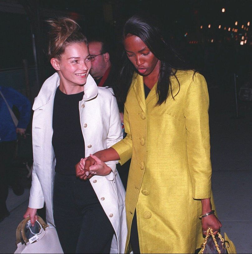 Kate Moss, à gauche, et Naomi Campbell se tiennent la main alors qu'elles partent après le défilé Versace le 12 avril 1997, lors de la Fashion Week de New York.