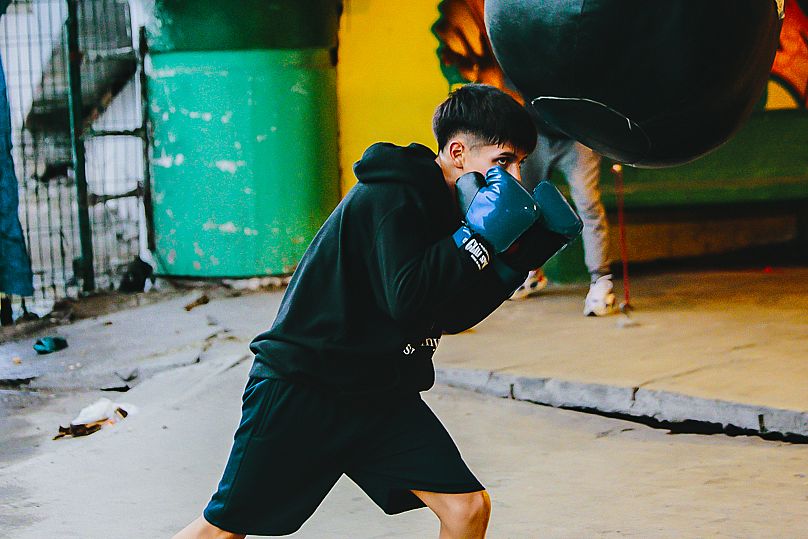 Un jeune combattant s'entraîne avec un sac de frappe au gymnase Ramirez, Ecatepec de Morelos, Mexique