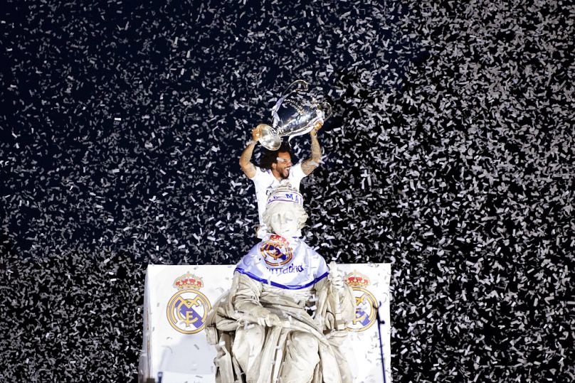 Le joueur du Real Madrid Marcelo tient le trophée de la Ligue des Champions sur la place Cibeles, devant l'hôtel de ville de Madrid, en mai 2022.