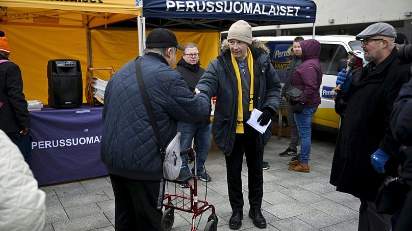 DOSSIER : Le candidat présidentiel du Parti finlandais, Jussi Halla-aho, au centre, fait campagne sur un marché à Vantaa, en Finlande, le 28 octobre 2023.