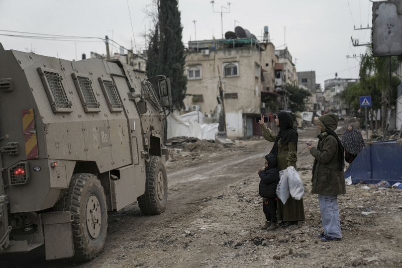Une Palestinienne brandit un signe en V en direction des troupes israéliennes lors d'un raid militaire dans le camp de réfugiés de Tulkarem, en Cisjordanie, le mercredi 17 janvier 2024.