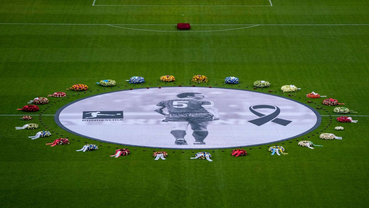 Flower wreaths surround a photograph of Bayern and Germany legend Franz Beckenbauer on the pitch of the Allianz Arena in Munich, Germany, Friday, Jan. 19, 2024