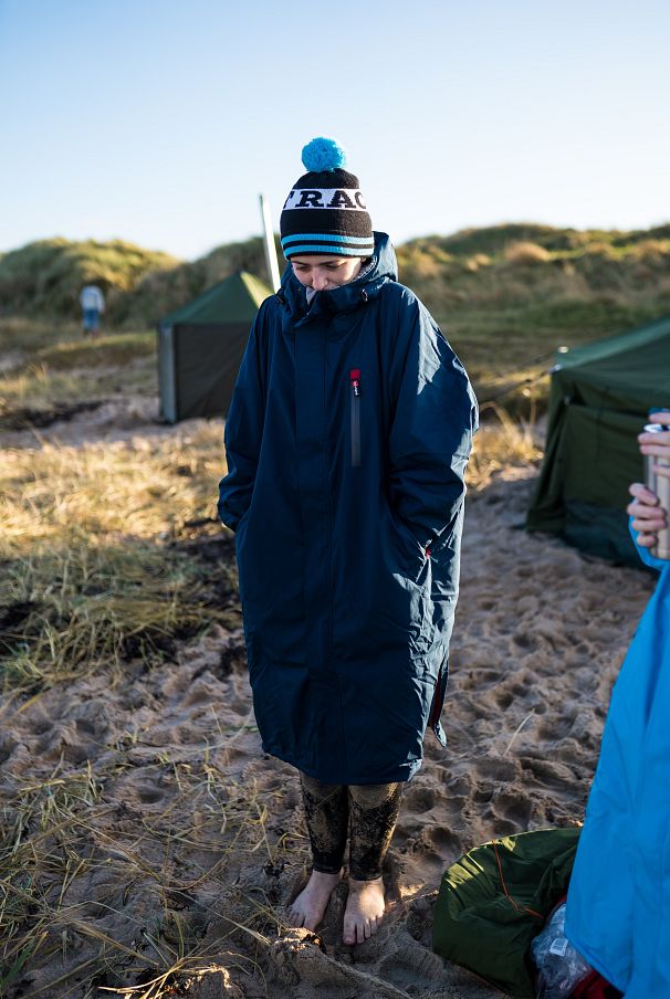 Hannah se réchauffe dans sa robe de change après un plongeon dans la mer du Nord