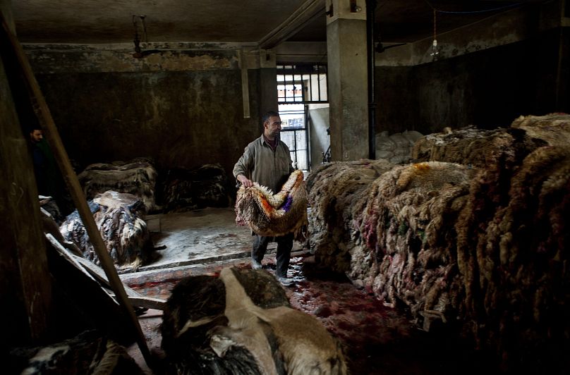 Un ouvrier d'une usine de Srinagar, en Inde, transporte des morceaux de cuir brut tanné
