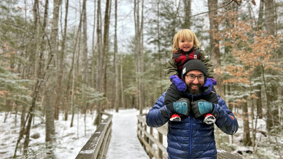 Christopher Roma carries his son Solomon on his shoulders in the White Mountains in New Hampshire in late 2023.