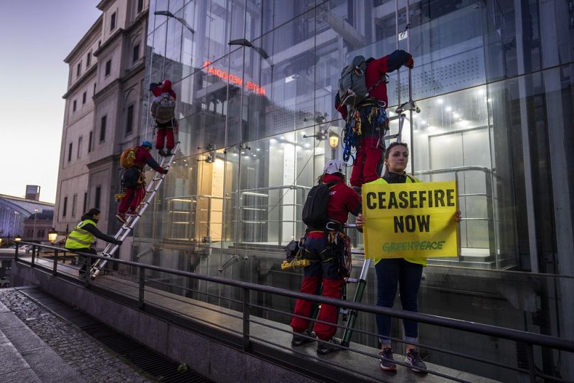Des militants de Greenpeace se préparent à grimper et à accrocher une illustration de l'artiste visuel américain Shepard Fairey 
