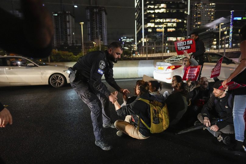 Des policiers israéliens dispersent des manifestants bloquant une autoroute lors d'une manifestation exigeant la libération immédiate des otages israéliens détenus dans la bande de Gaza par le Hamas.