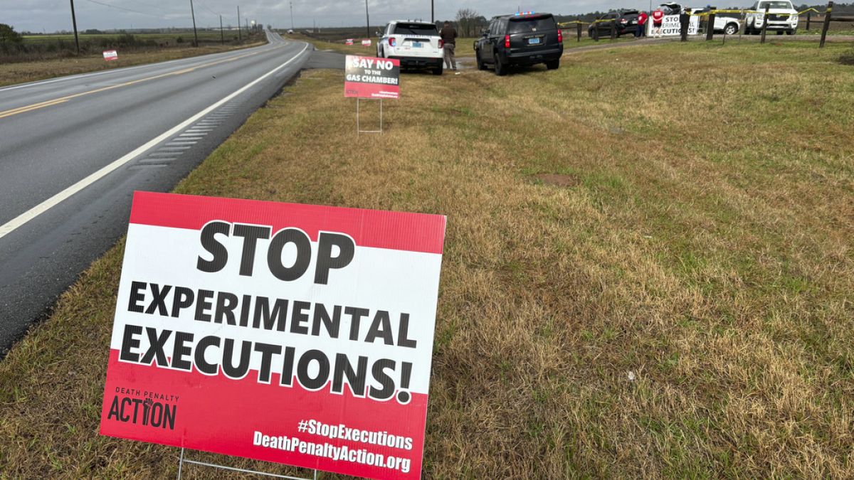 Anti-death penalty activists place signs along the road heading to Holman Correctional Facility in Atmore, Ala., ahead of the execution of Smith on Thursday.