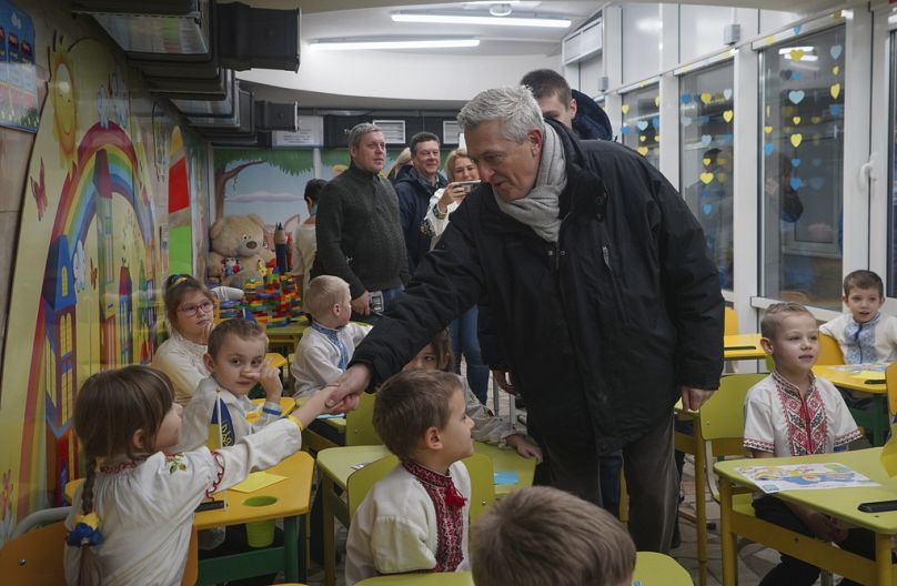 Le Haut Commissaire des Nations Unies pour les réfugiés, Filippo Grandi, salue les élèves lors de sa visite dans une école de Kharkiv, en Ukraine, le lundi 22 janvier 2024.