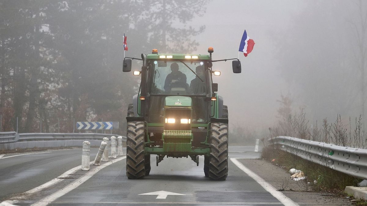 A farmer drives his tractor on a highway, near Agen, southwestern France, 27 January 2024.