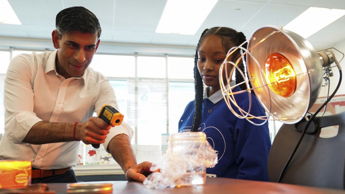 British Prime Minister Rishi Sunak takes part in a science experiment as he visits the Friendship Technology Preparatory High School during his trip to Washington, Wednesday,