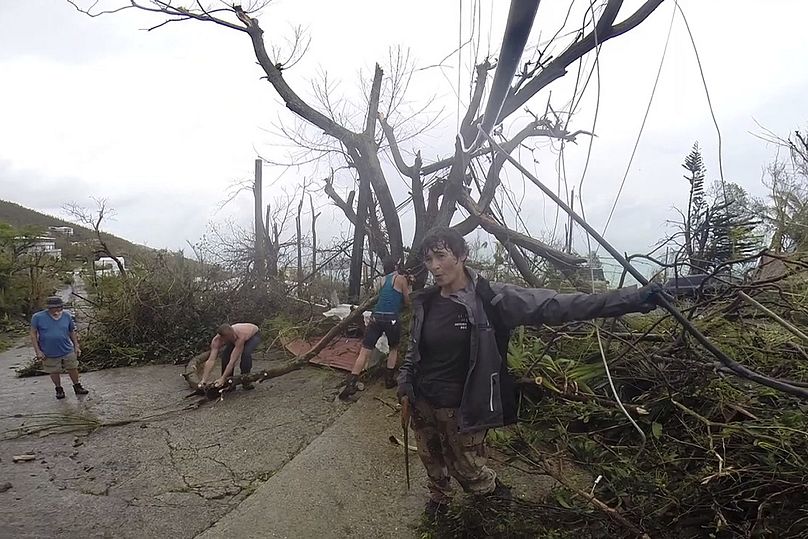 Des voisins nettoient les débris de la route à la suite de l'ouragan Irma, à St. Thomas, USVI, septembre 2017.