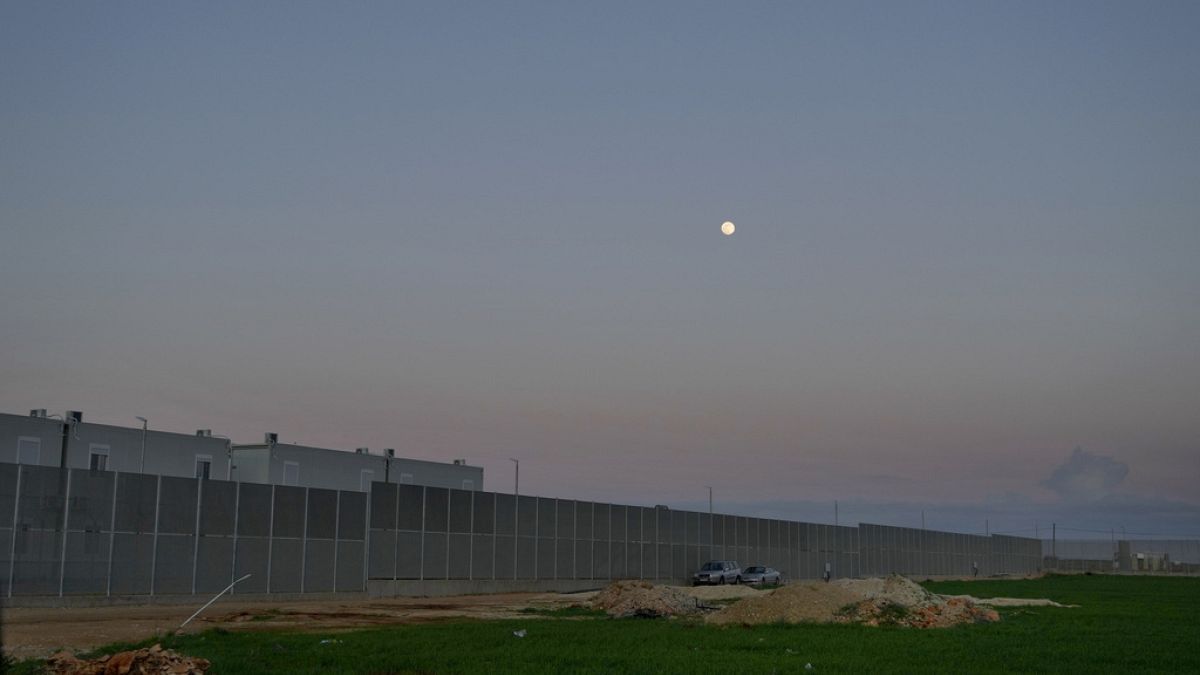 The moon rises over the Pournara migrant reception center in Kokkinotrimithia outside of capital Nicosia, Cyprus on Wednesday