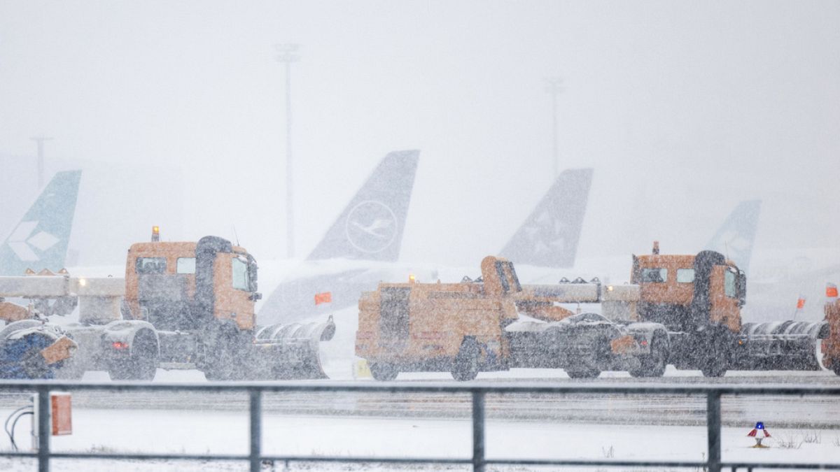 Snow clearing vehicles drive past parked airplanes at Frankfurt Airport during heavy snowfall in Frankfurt am Main, Germany, Thursday, Jan 18, 2024.