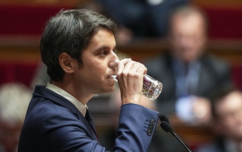 Le Premier ministre français Gabriel Attal boit un verre d'eau lors de son discours devant les législateurs à l'Assemblée nationale à Paris.