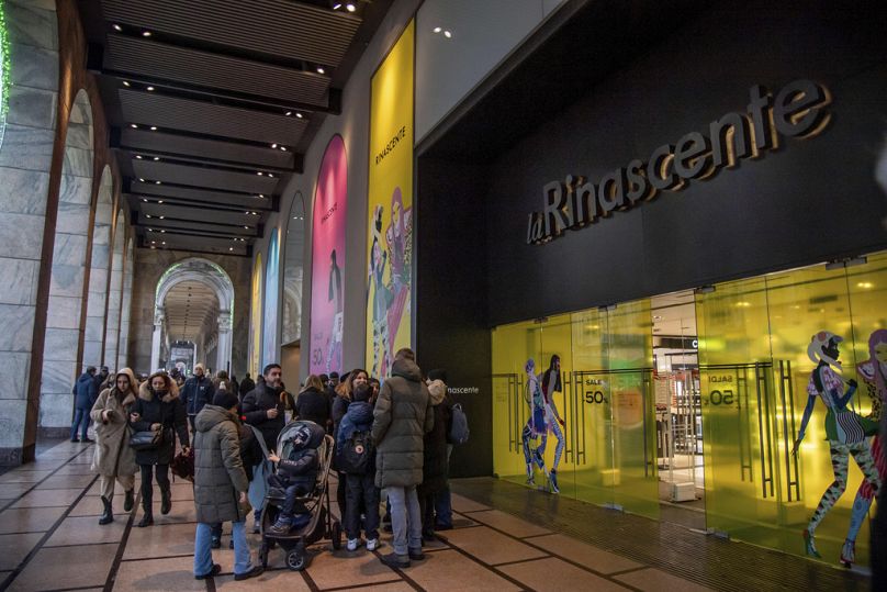 Des gens se promènent dans une rue commerçante du centre-ville de Milan, en Italie, lors du premier jour de soldes, le vendredi 5 janvier 2024.