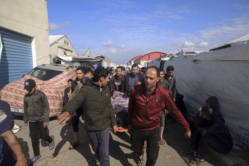 Des Palestiniens transportent le corps d'une personne tuée dans le bombardement israélien contre un bâtiment d'un centre de formation professionnelle de l'UNRWA qui sert d'abri aux personnes déplacées.