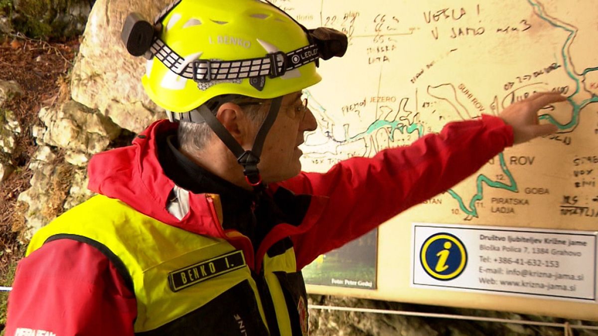 A rescuer inspects the map of Krizna Jama cave near Grahovo, Slovenia on Sunday