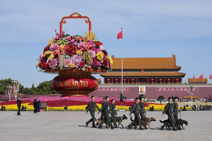Des responsables de la sécurité marchent avec des chiens sur la place Tiananmen lors de la cérémonie d'ouverture du Forum de la Ceinture et de la Route à Pékin, en octobre 2023.