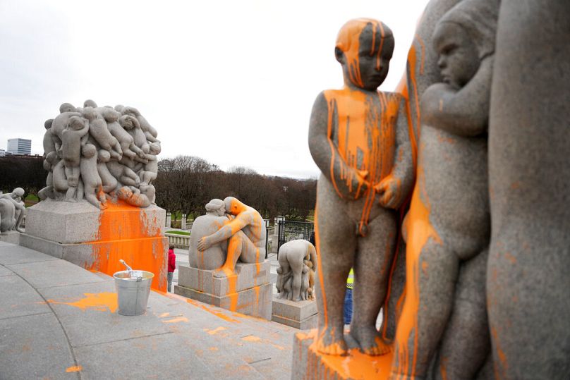 Les sculptures sont recouvertes de peinture orange après que des militants de Stopp oljeleting (Stop Oil Now) les ont recouvertes de peinture dans le parc de sculptures Vigeland à Oslo, novembre 2022.
