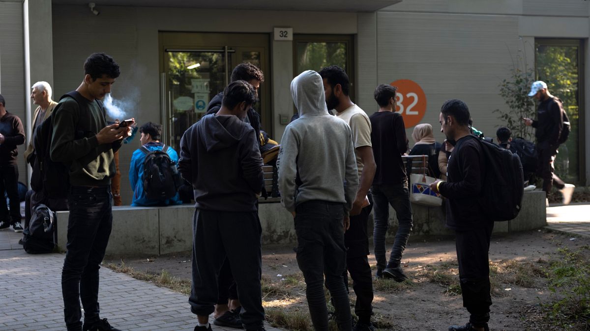 FILE - Dozens of people from all over the world line in front of the central registration center for asylum seekers in Berlin, Germany, Monday, Sept. 25, 2023.