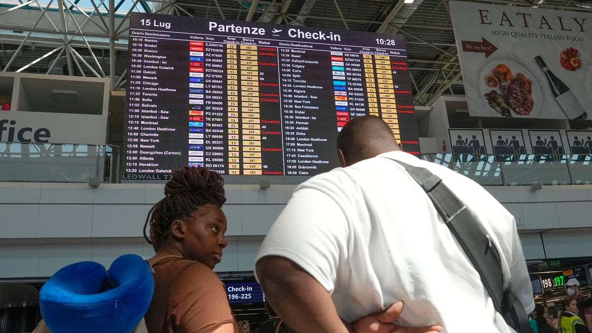 Passengers look at check-in times for flights during a nationwide strike of airports ground staff, and check-in services at Rome