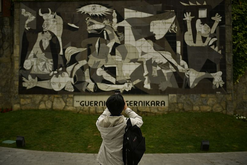 Un visiteur prend des photos d'un mur décoré du célèbre tableau ''Guernica'' de Pablo Picasso en Espagne basque