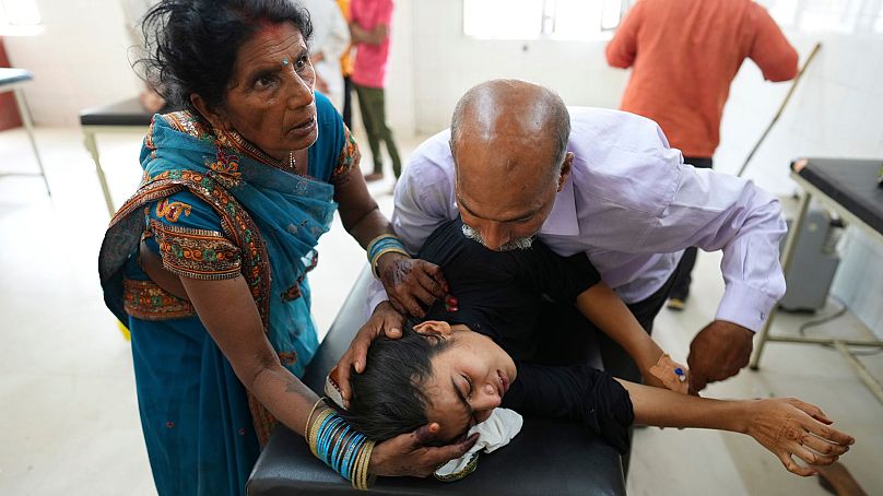Un père tente de calmer sa fille souffrant d'une maladie liée à la chaleur à l'hôpital de Ballia, dans l'État de l'Uttar Pradesh, en Inde, en juin 2023.