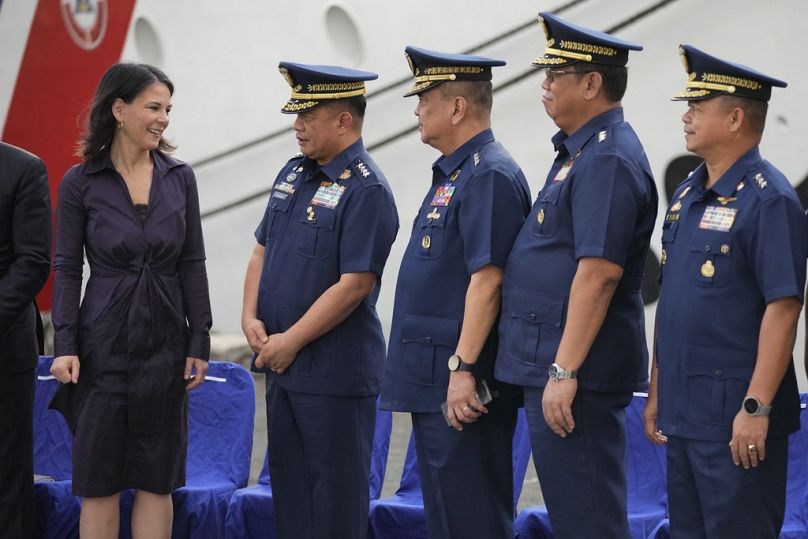 La ministre allemande des Affaires étrangères Annalena Baerbock, à gauche, s'entretient avec le commandant des garde-côtes philippins, l'amiral Ronnie Gil Gavan, deuxième à gauche, et d'autres officiers lors de sa visite.