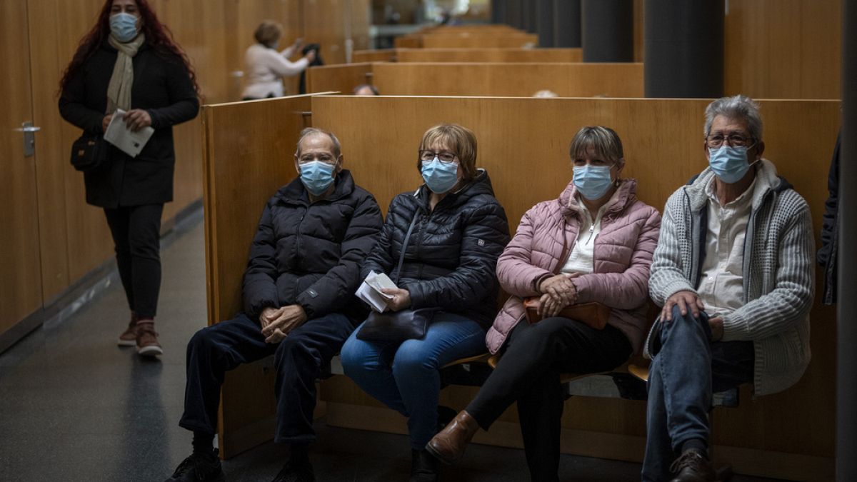 People wearing face masks as a precaution wait for a doctor appointment inside a hospital in Barcelona, Spain, Monday, 8 January, 2024.