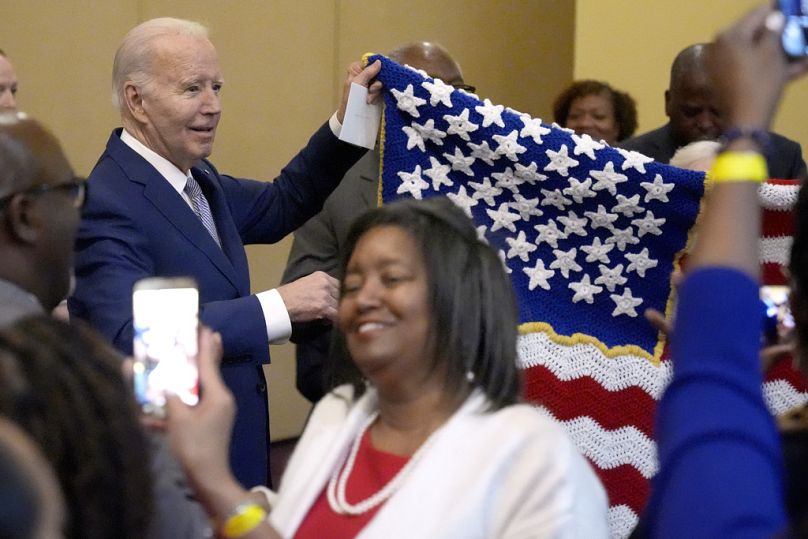 Le président Joe Biden brandit un drapeau fabriqué à la main, offert par un partisan.
