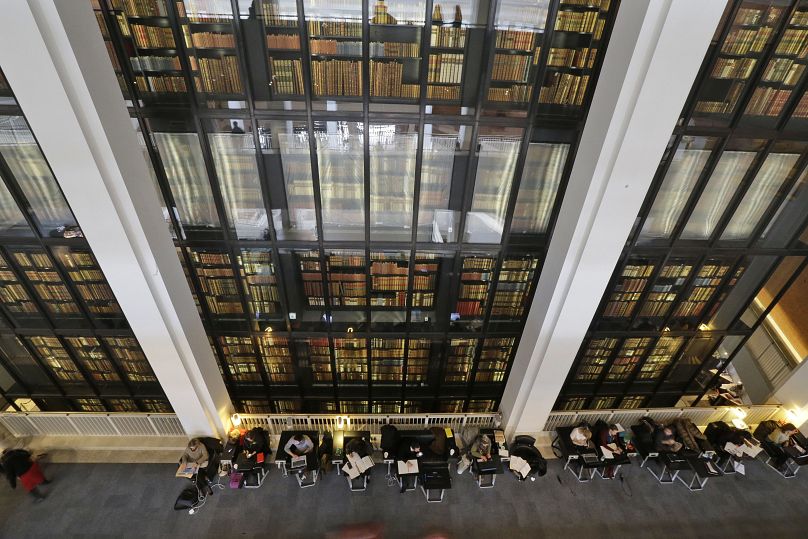 Des gens travaillent derrière des livres à la British Library