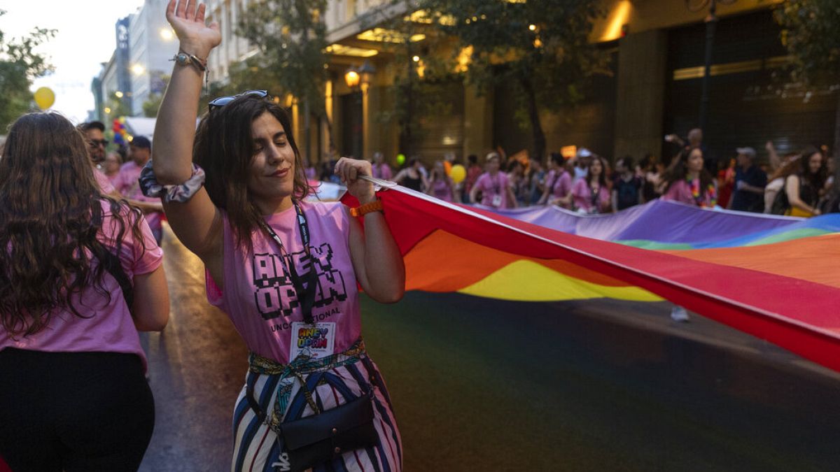 A woman dances as she holds a rainbow flag at the annual Gay Pride rally in Athens in 2022