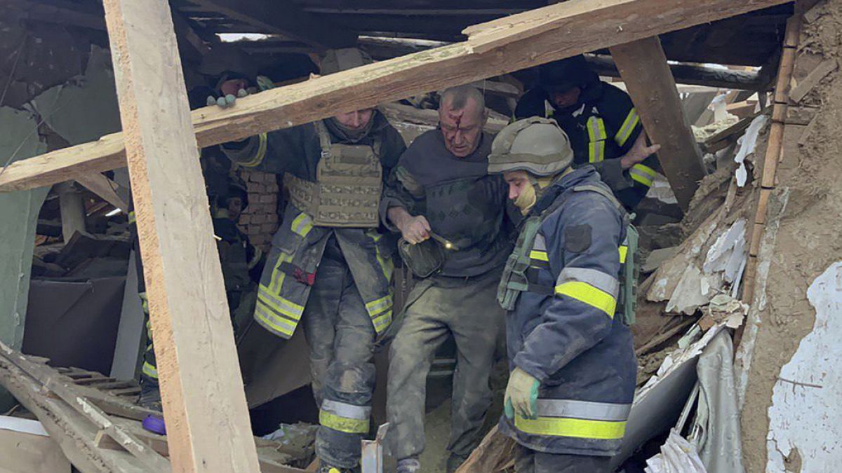 Emergency workers help a wounded man after residential houses were damaged in a Russian missile attack, near Kryvyi Rih, Ukraine, Monday, Jan. 8, 2024r