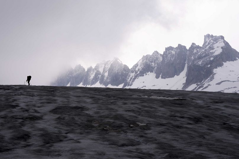 Un caméraman se dirige vers le glacier du Rhône, près de Conches, en Suisse.