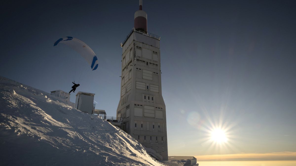 A paraglider takes off from the snow-covered Mont Ventoux, southeastern France, Saturday, Jan. 13, 2024