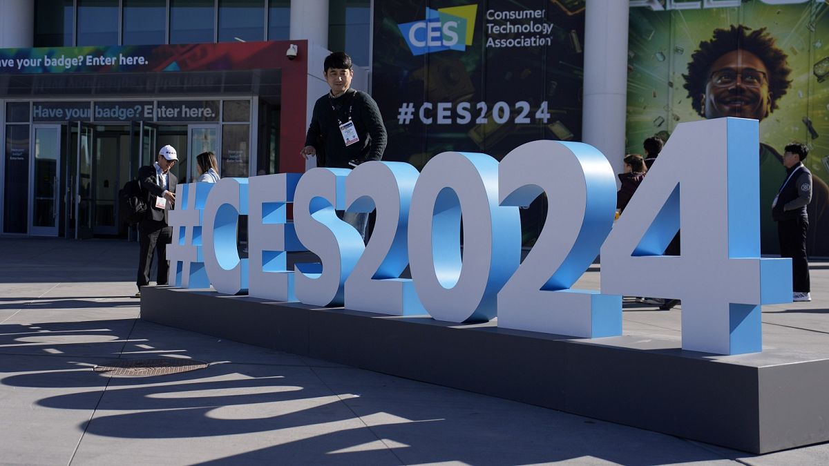 People walk by a CES sign during the CES tech show Wednesday, January 10, 2024, in Las Vegas.