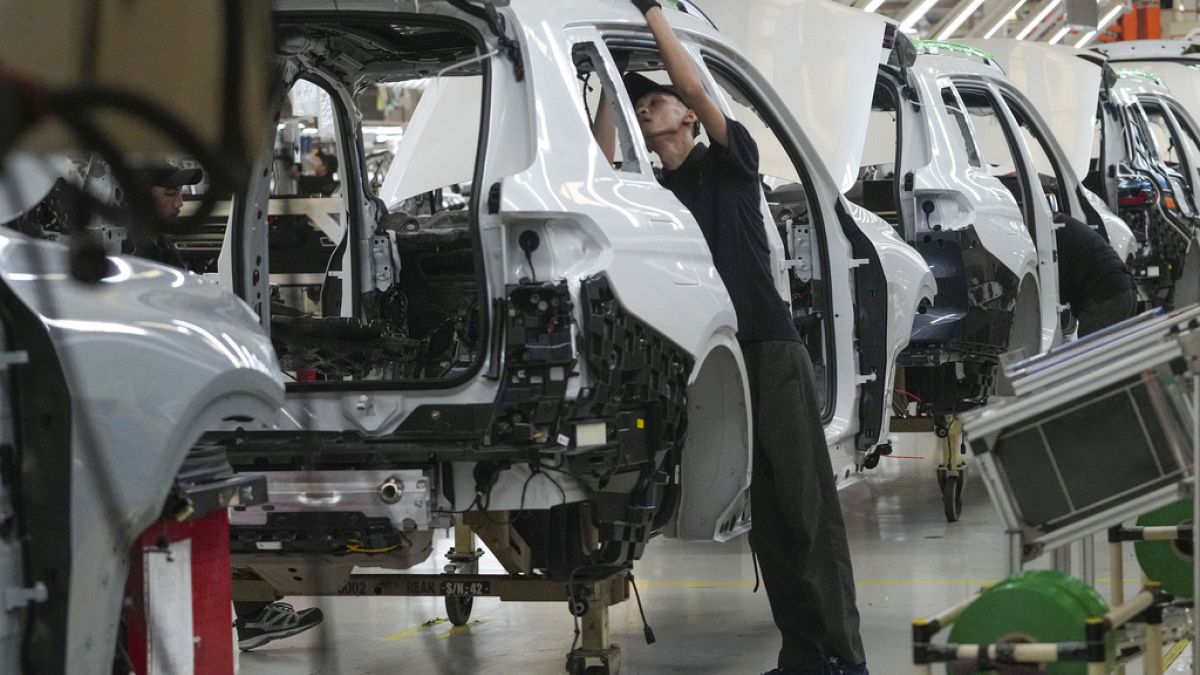 An employee works on a car on the assembly line at the BMW Production Network 2 at Gaya Motor plant in Jakarta, Indonesia, Tuesday, June 6, 2023. (AP Photo/Tatan Syuflana)